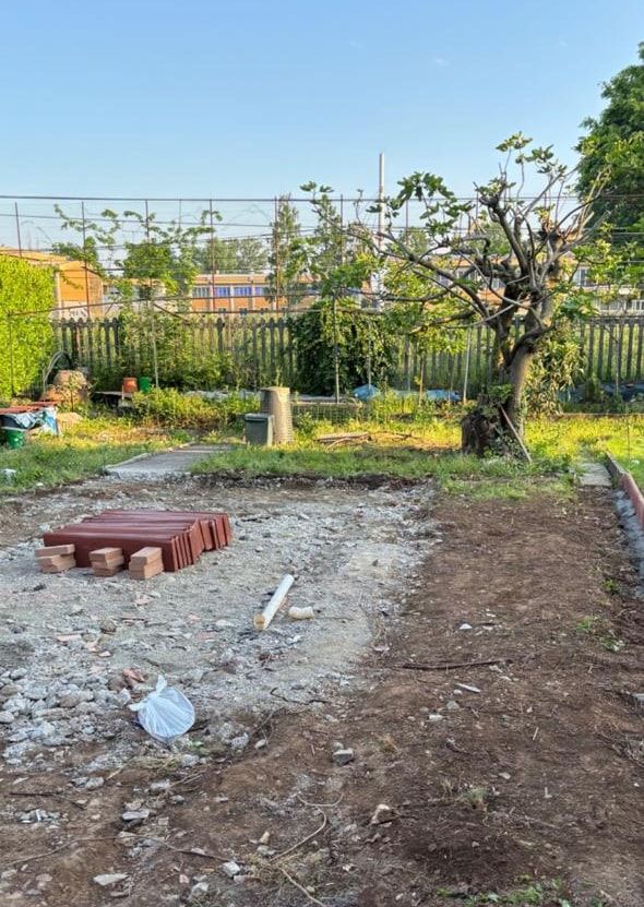 Prima: il terreno in giardino con la ghiaia, la terra smossa e i materiali appoggiati
